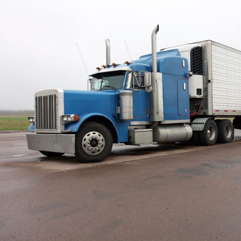 A blue truck is parked on the side of the road.