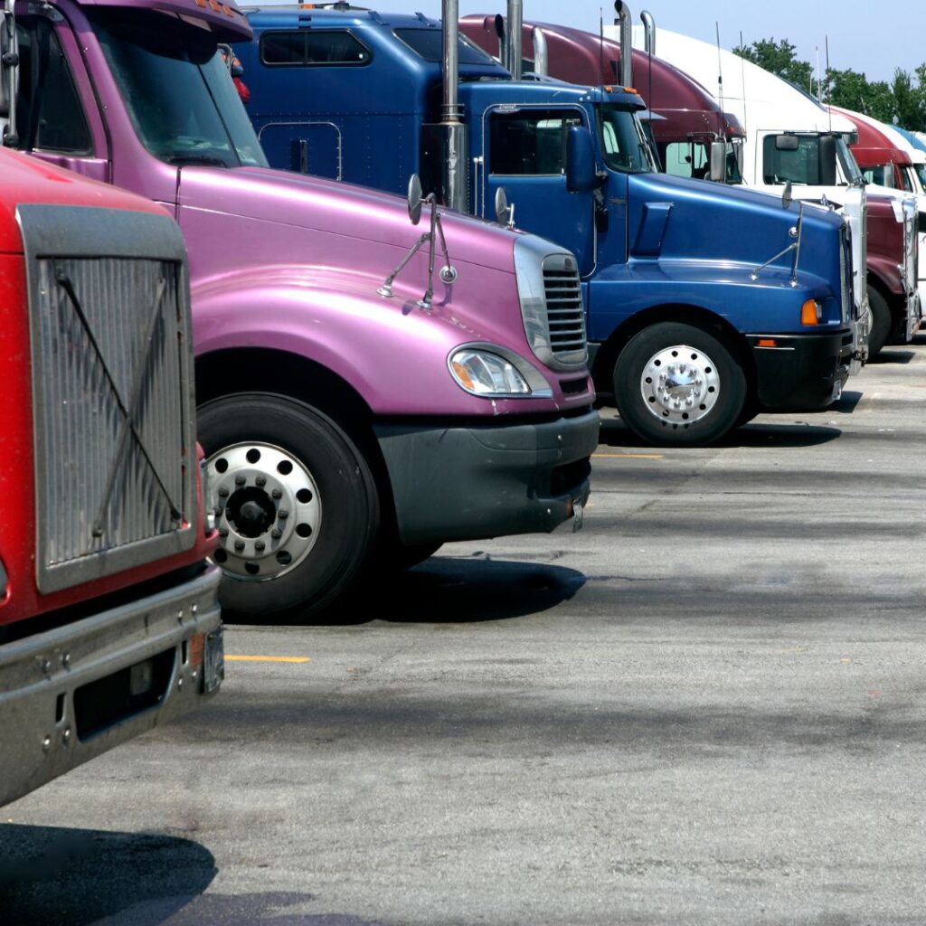 A row of trucks parked in a parking lot.