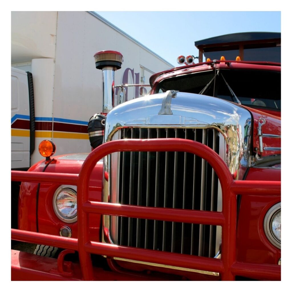 A close up of the front end of a red truck.