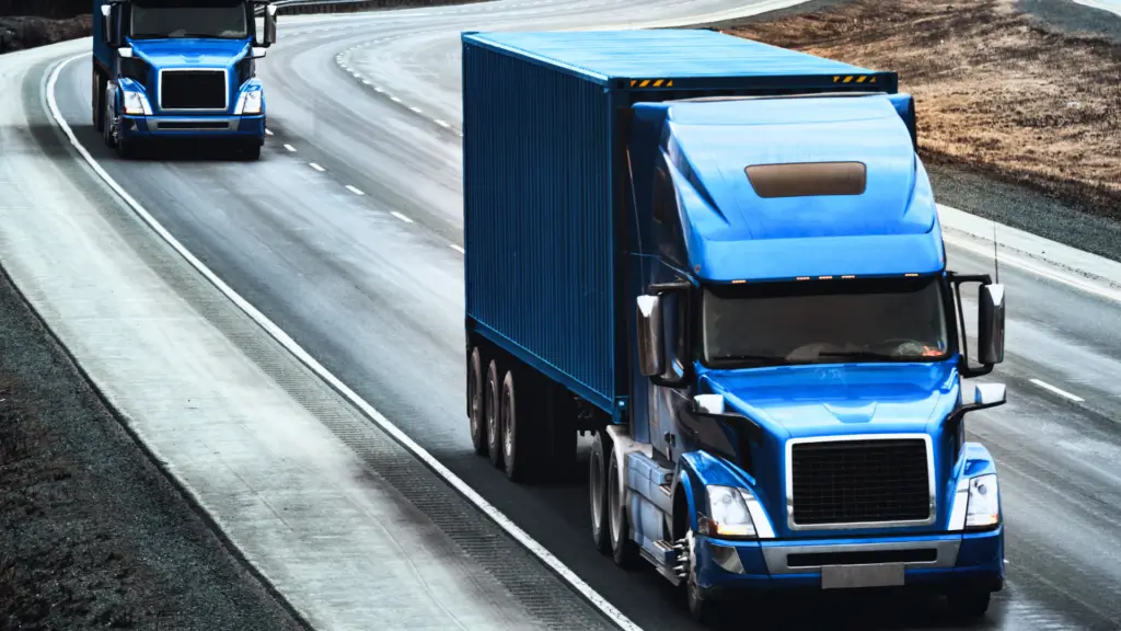 A blue truck is driving down the street