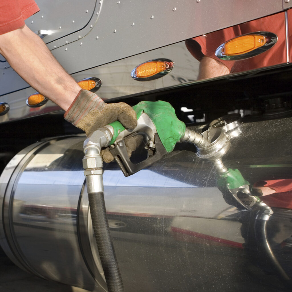 A person pumping gas into the tank of a truck.